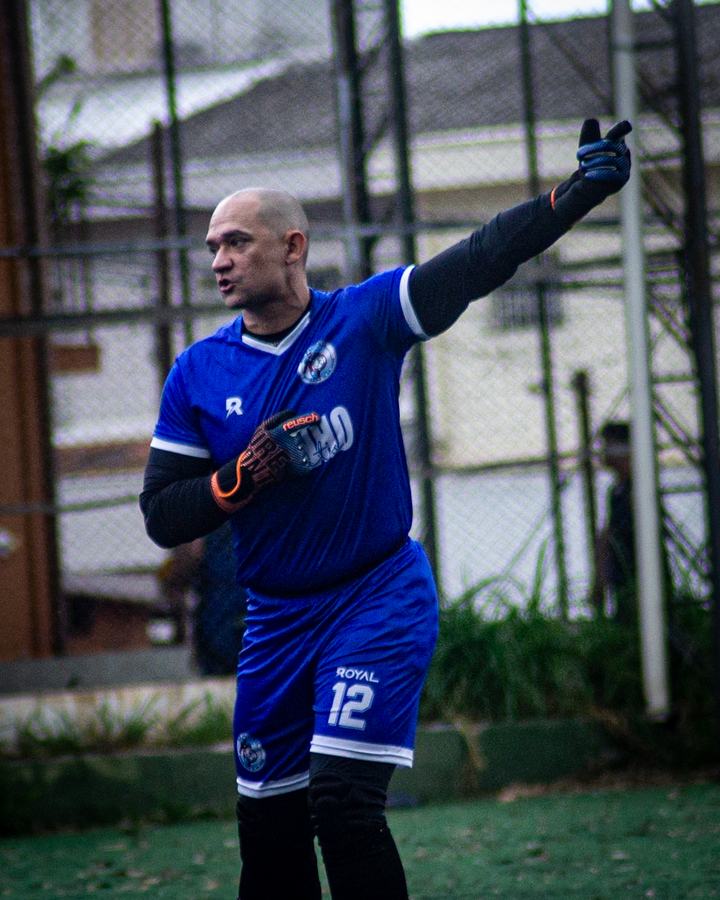 Jogador de futebol de várzea contra a luz, atmosfera de gol