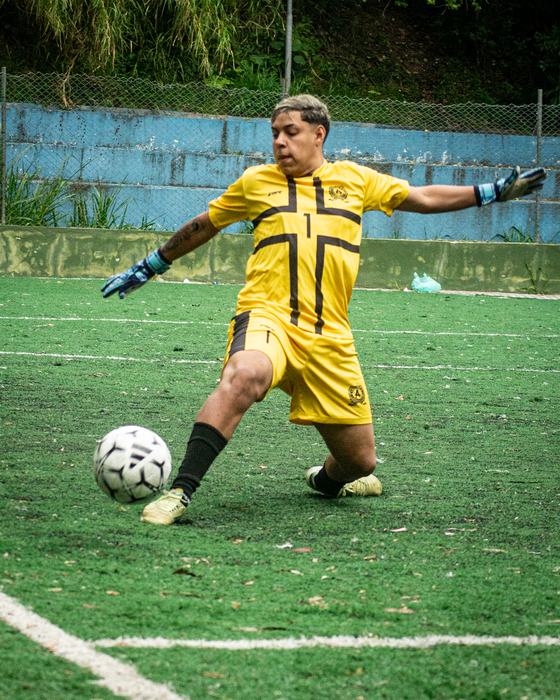 Disputa de bola no ar em jogo de futebol de várzea